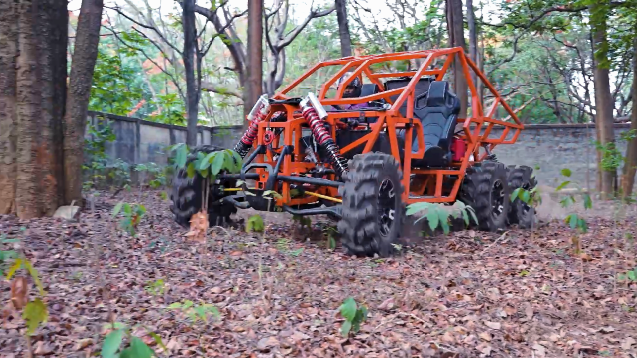 A vibrant orange UTV nestled among trees, with a carpet of leaves covering the forest floor.