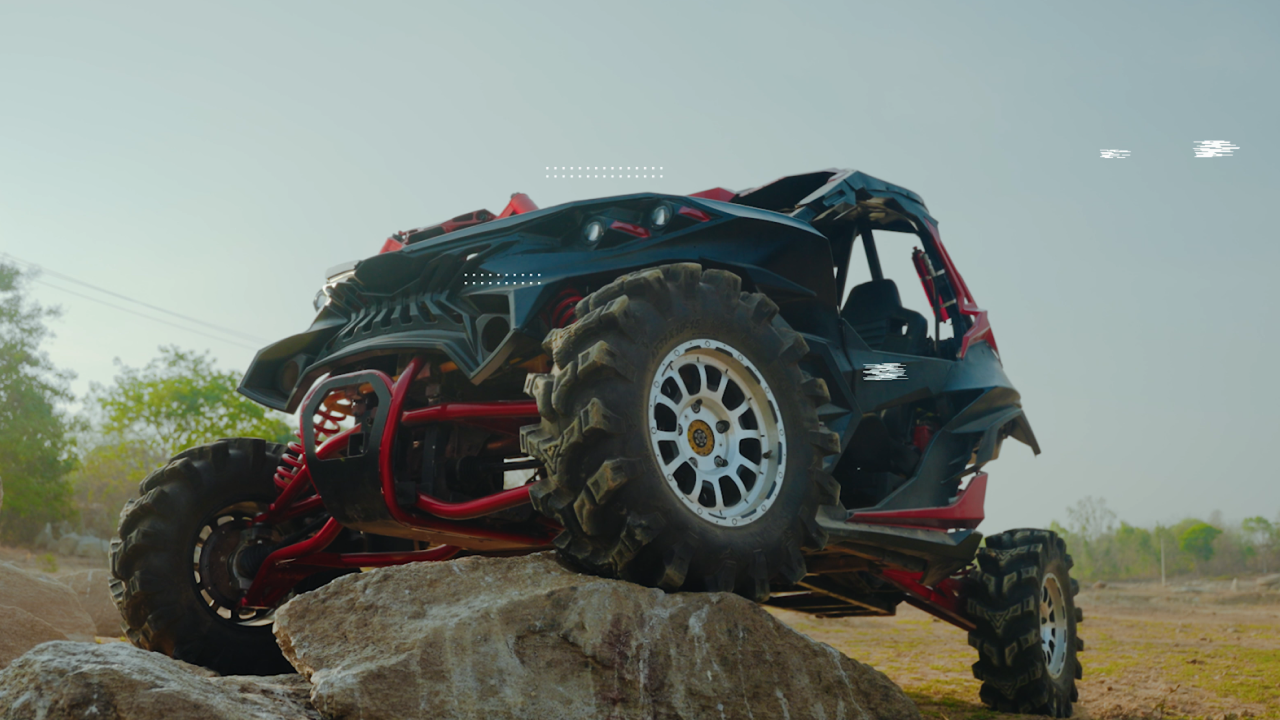 Red and black colour Ashva 4x4 parked on a rugged rock surface, showcasing its off-road capabilities.