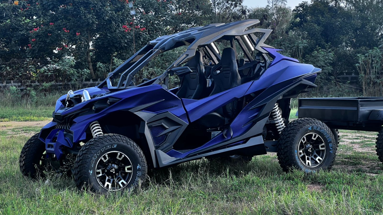 Red and black colour Ashva 4x4 parked on a rugged rock surface, showcasing its off-road capabilities.
